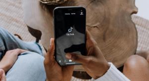 a person holding a hand with a mobile with tik tok displayed