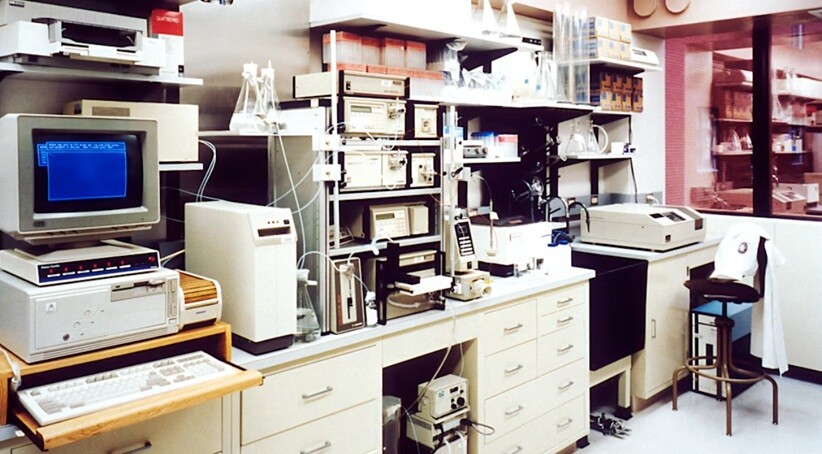a clinical lab showing computer, printer, files, table and chairs