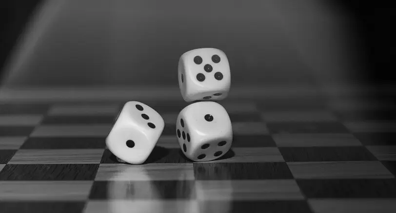 three dice being rolled and being dropped on the floor in black and white
