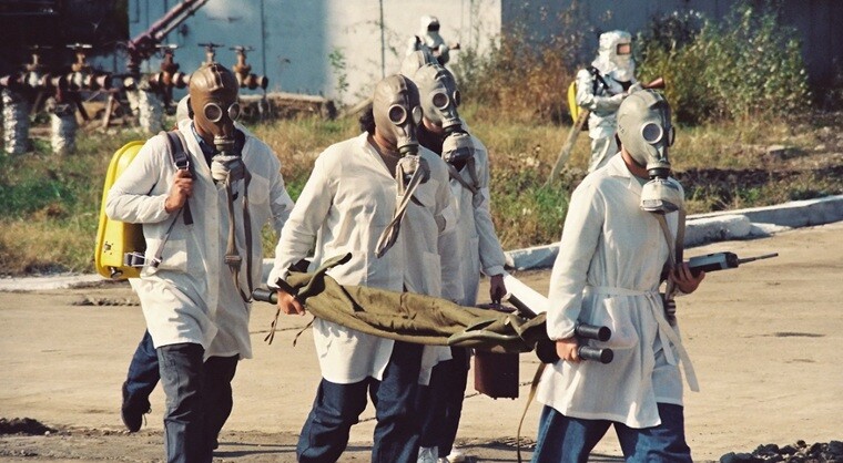 a group of people wearing masks in a chemical hazardous situation in a factory