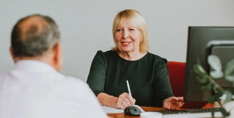 a lady lawyer taking to a client over a table