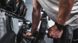 a muscular man with strong arms trying to lift heavy weights