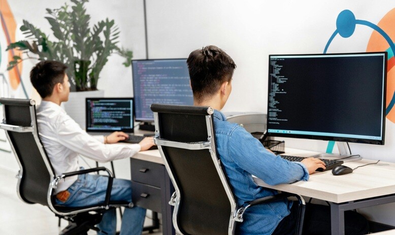 two persons working on desktops to give AI services