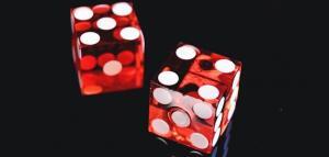two dice in red color being rolled in the black background