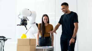 two students discussing on a robotic laser arm