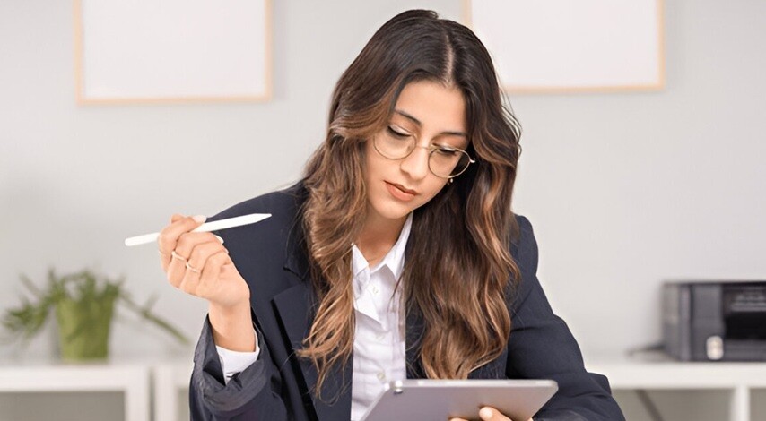 a lady accountant using her tablet and her pen as analyzing the data