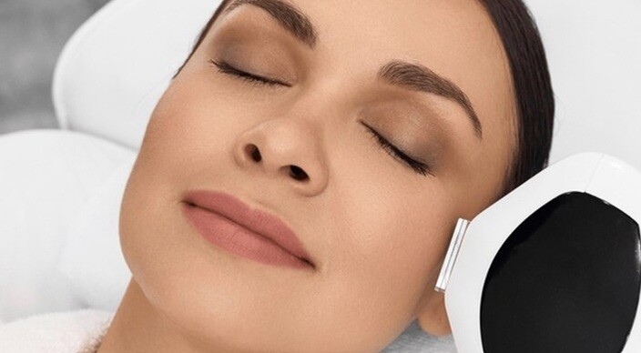 a lady undergoing facial treatment with a machine