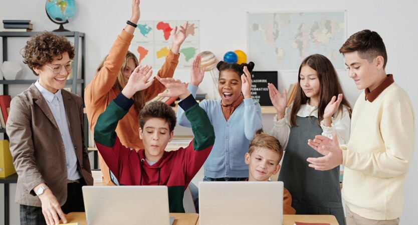 teenage students learning looking at the laptops in a classroom