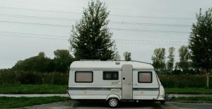 a motor home seen parked on a road with trees beside it