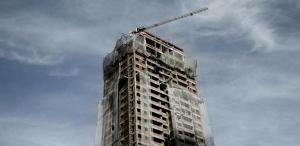 a building seen that is ready to be demolished with grey blue sky background