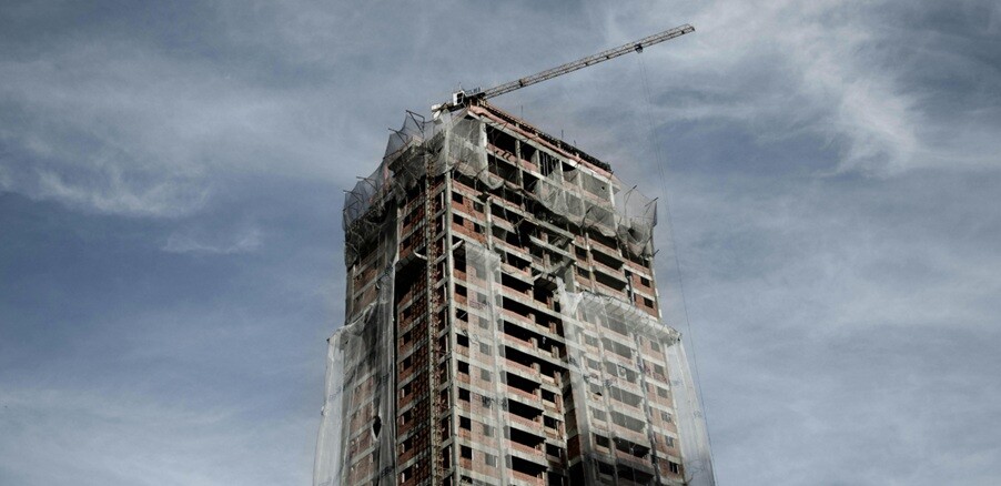 a building seen that is ready to be demolished with grey blue sky background