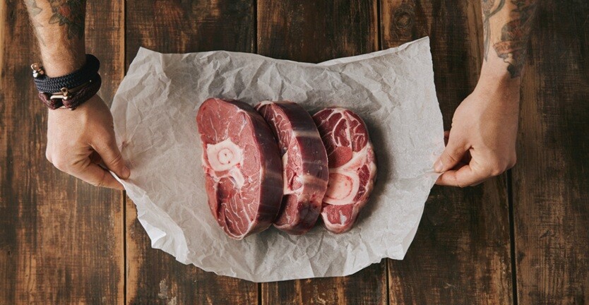 three pieces of meat placed in a clean paper found on a table