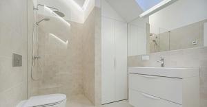 clean white bathroom with basin, shower and closet