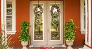 front porch of a beautiful house with green plants on either side of the front door