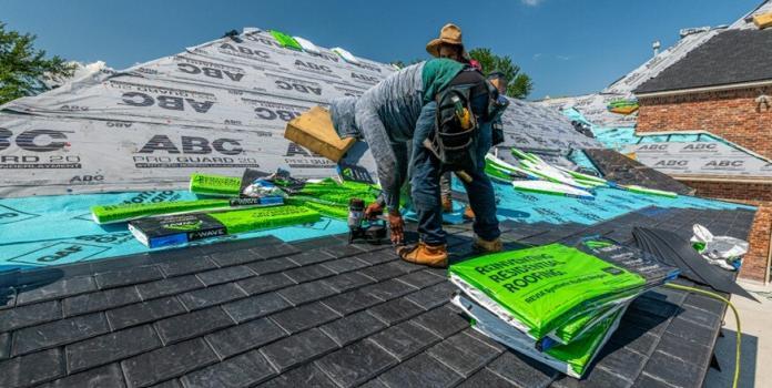 two persons working on a roof top of a house