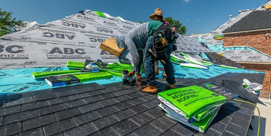 two persons working on a roof top of a house