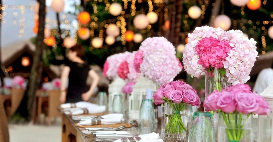table with plates, flowers and lights placed in an island