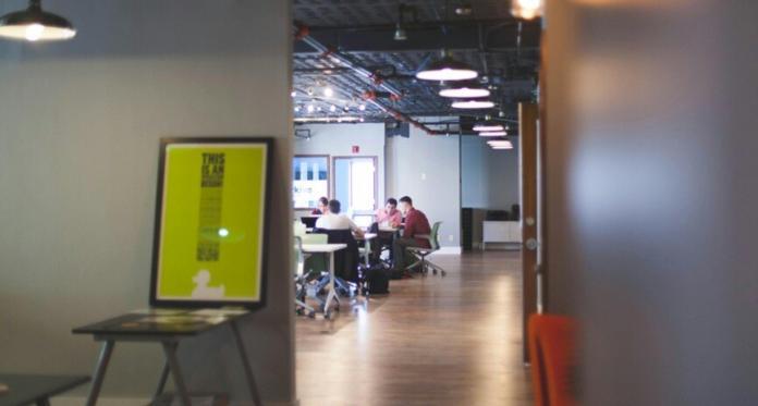 an office space where a group of people are working with lights on